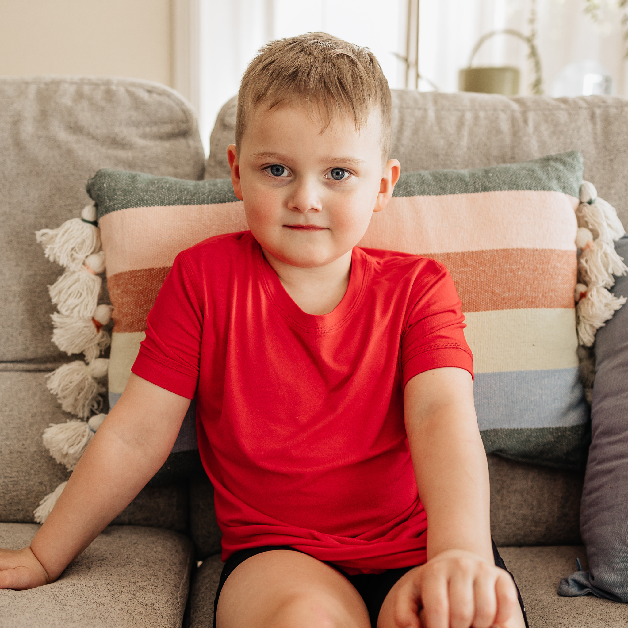 A boy wearing ruby Bamboo t-shirt from comfort on the spectrum