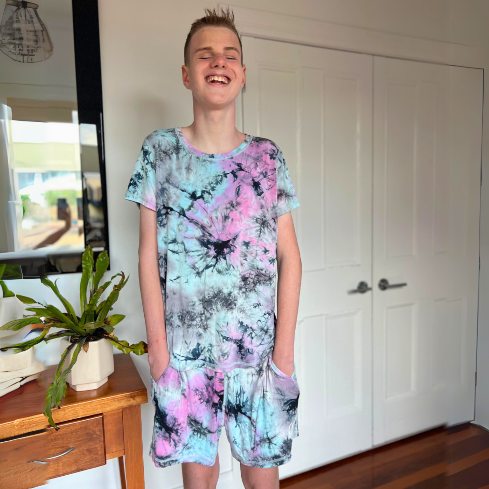 A boy wearing Comfort on the Spectrum - Cosmic Splash sensory friendly clothing adults .