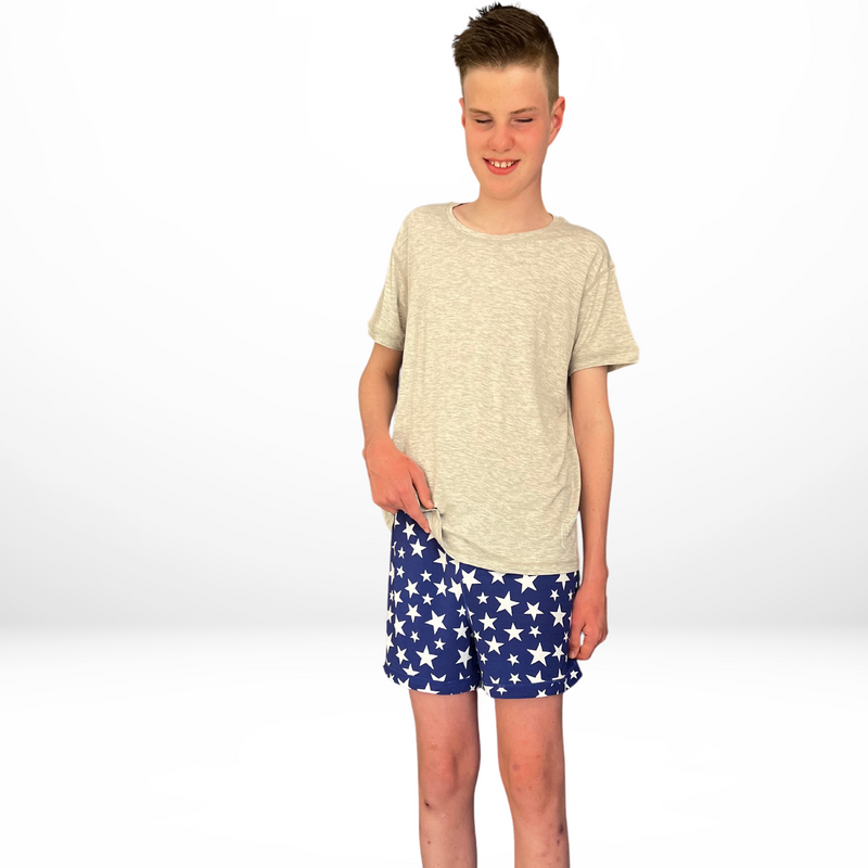 Standing boy wearing the stars short set - pajama short set from Comfort on the Spectrum.