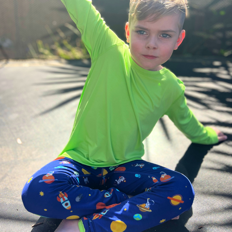 A boy wearing a space invaders long set - pajamas for teens from Comfort on the Spectrum.