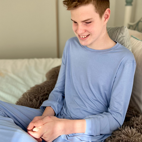 A boy wearing blueberry long set - pajama set for teens - from Comfort on the Spectrum.