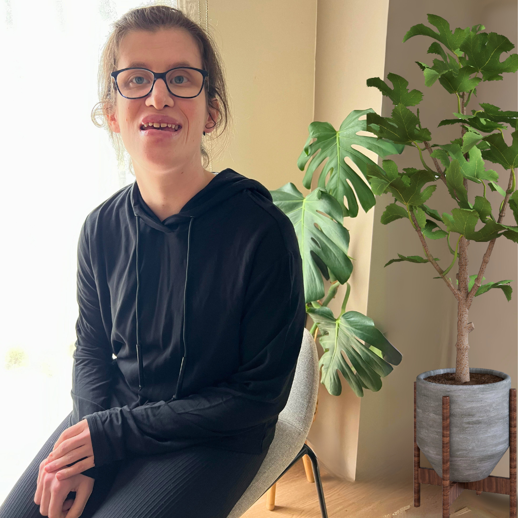 A sitting girl wearing the midnight sensory hoodie from Comfort on the Spectrum.