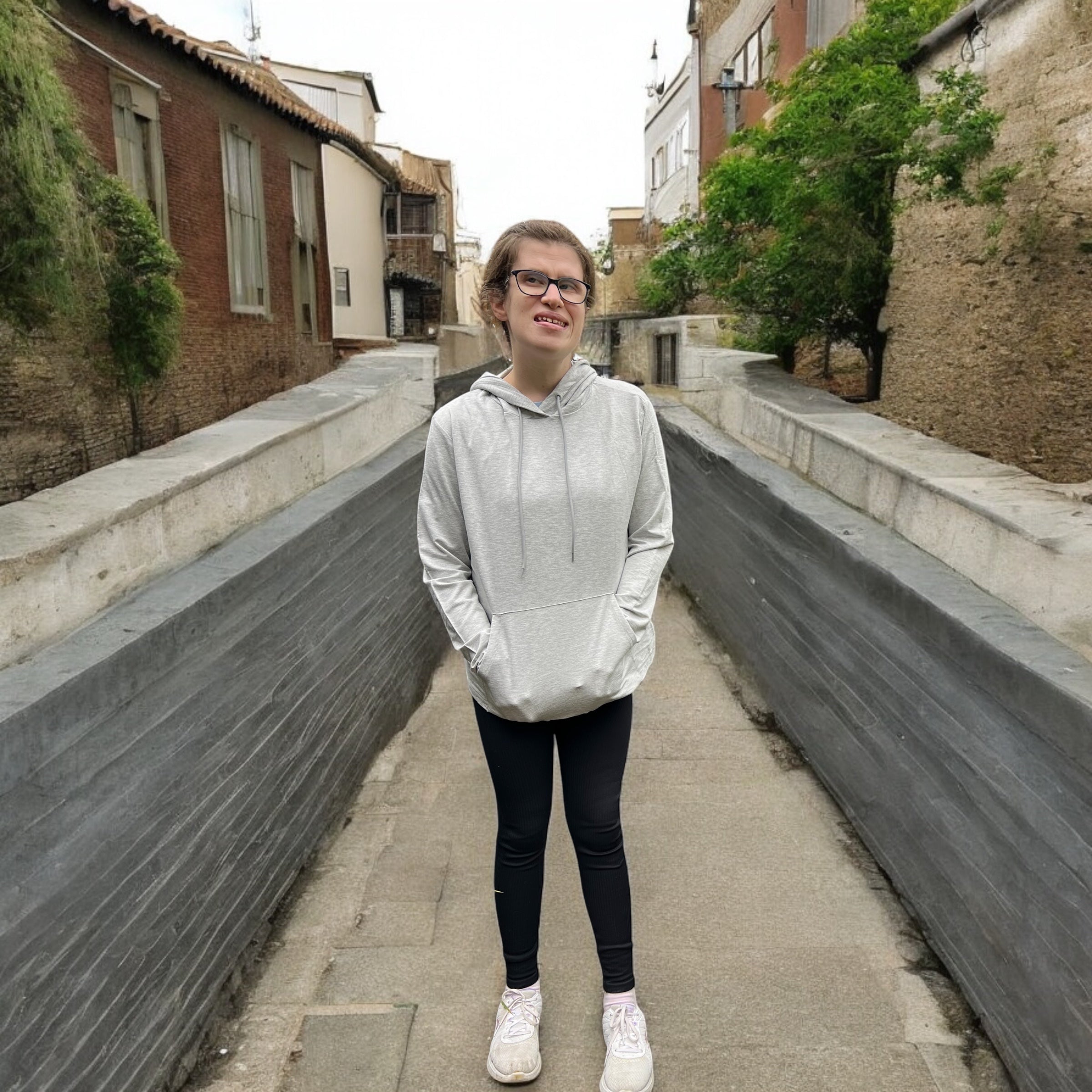 A smiling women wearing the grey marle sensory hoodie from Comfort on the Spectrum.