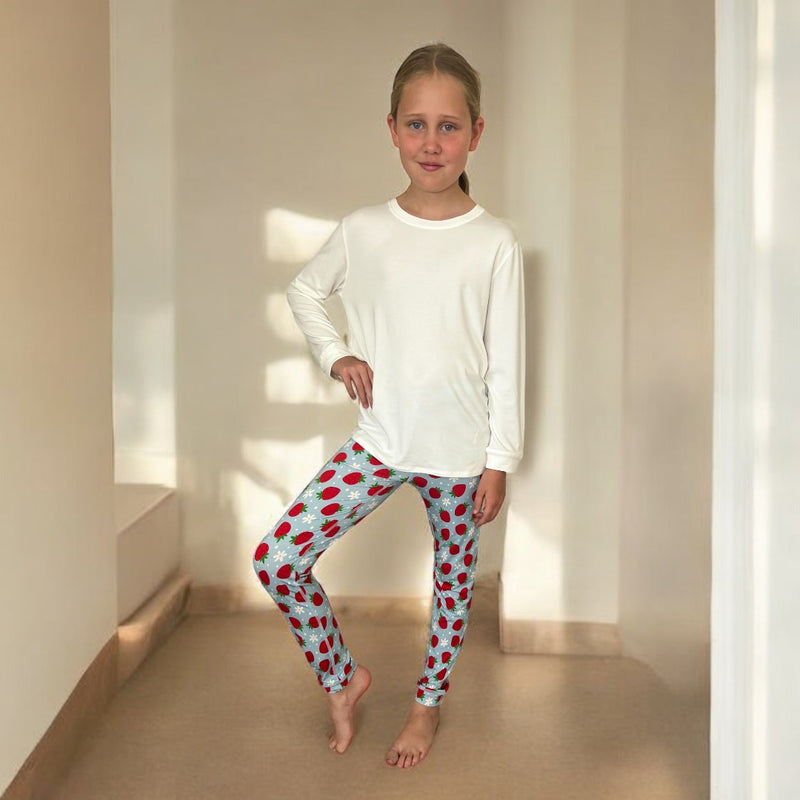 A standing girl wearing strawberries and cream long set - pajamas for teens from Comfort on the Spectrum.