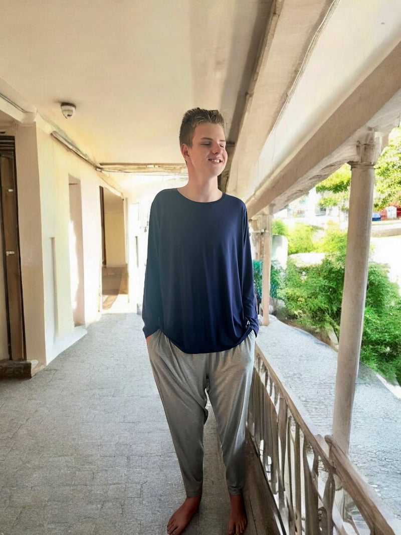 A  standing guy wearing the grey marle Australia's lounge pants from Comfort on the Spectrum.