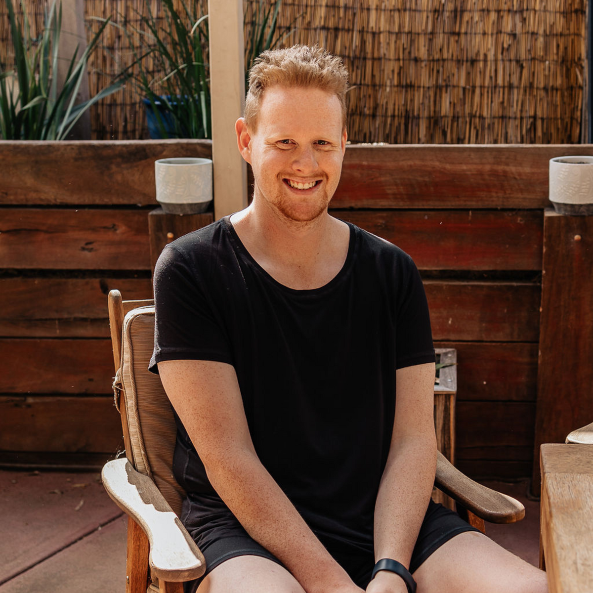 A smiling man wearing the midnight bamboo t shirt from Comfort on the Spectrum, sensory friendly pajamas for adults