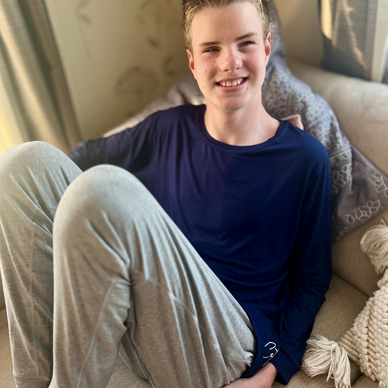 A man sitting on the couch wearing the navy long sleeve top -  basic long sleeve tops from comfort on the spectrum.