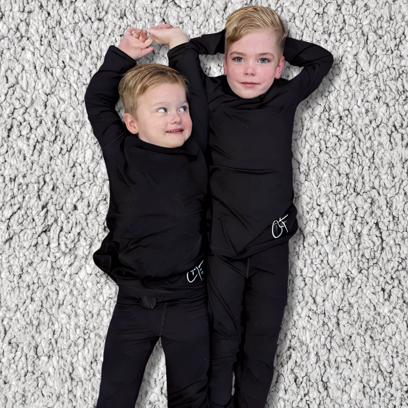 Two boys lying on the ground wearing midnight long set - pajamas for teens - from Comfort on the Spectrum. 