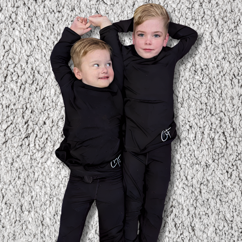Two boys lying on the ground wearing midnight long set - pajama set for teens - from Comfort on the Spectrum. 