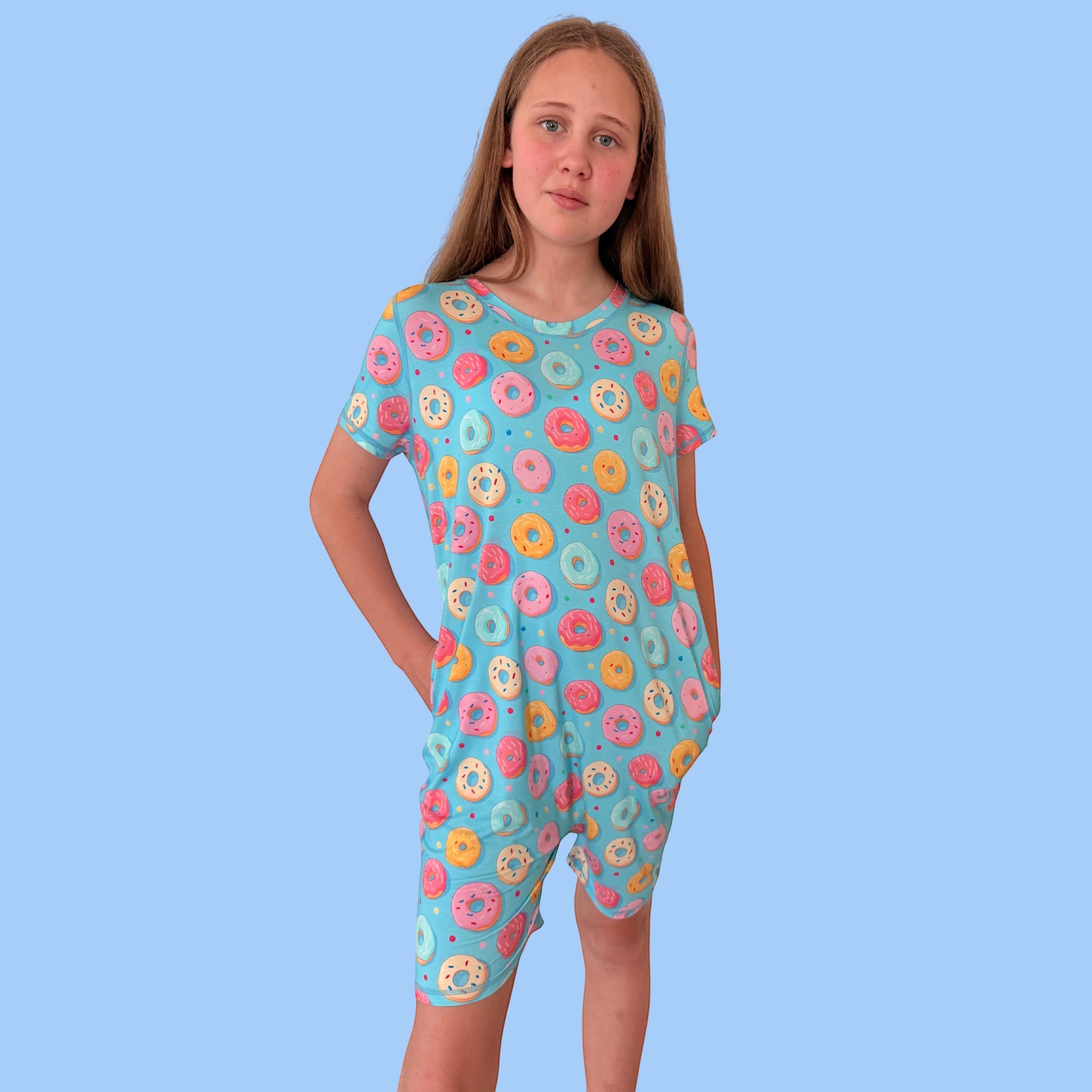 Comfort on the Spectrum blue short-sleeve playsuit with all-over donut print, made from soft bamboo blend. Features snap buttons at the back.