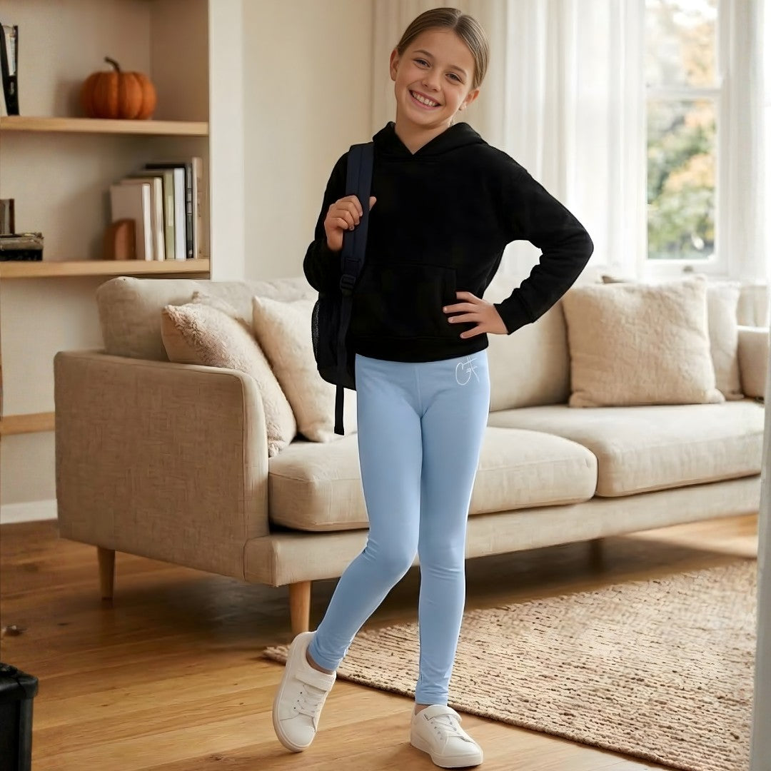 Comfort on the Spectrum black sensory-friendly hoodie with front pouch pocket and light blue leggings worn by a young girl.