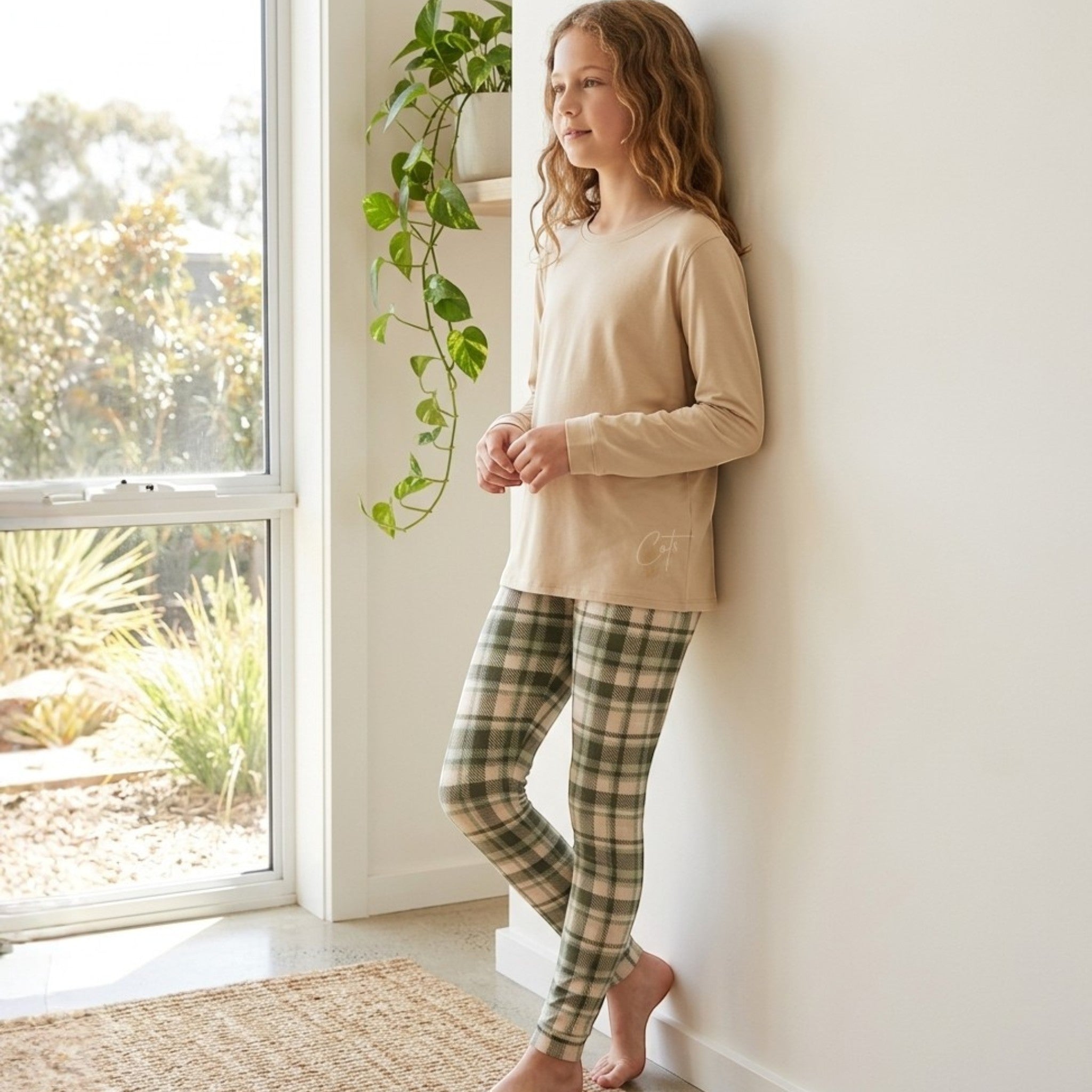 Comfort on the Spectrum kids long set in evergreen plaid bamboo fabric. Features a tan long-sleeve top and green plaid leggings.