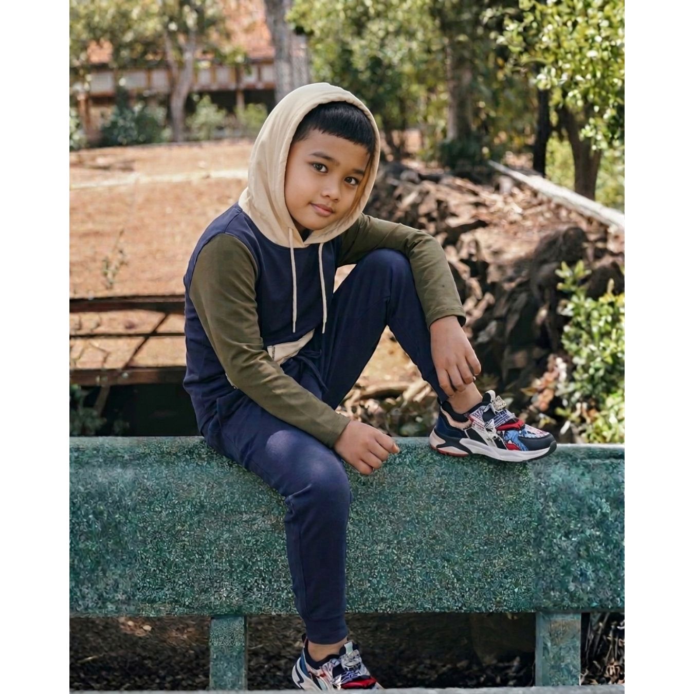 Comfort on the Spectrum navy bamboo/cotton blend tracksuit pants worn by a young boy sitting outdoors.