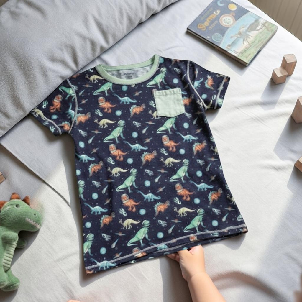 Comfort on the Spectrum navy t-shirt with space dinosaurs print, light green pocket, and light green trim.