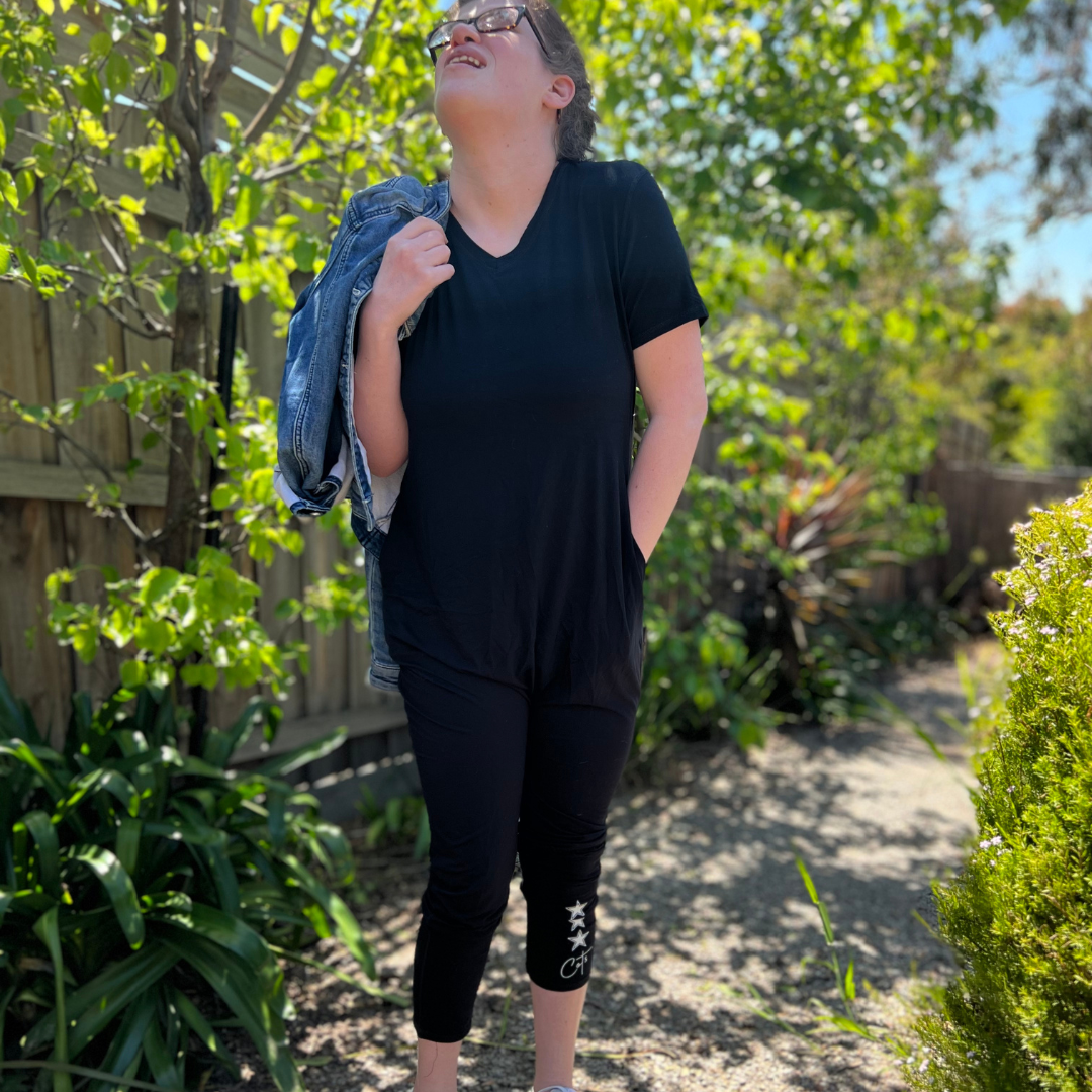 A standing lady wearing Onesie Pajamas for Adults  - midnight jumpsuit from Comfort on the Spectrum. 